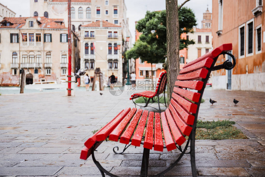 意大利威尼斯的红色长凳和古老建筑背景有选择地以红板和图片