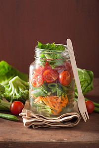玻璃瓶中的健康蔬菜沙拉番茄西兰花胡萝卜豌豆图片