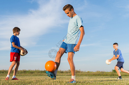 男孩在球场上进行足球训练背景图片