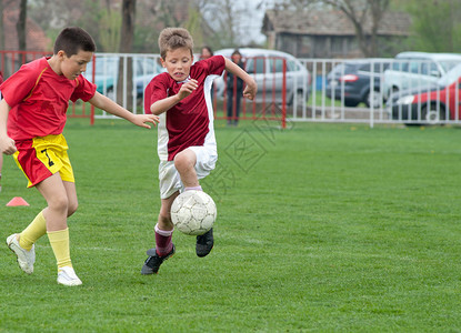 男孩在场上踢球背景图片