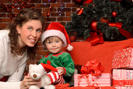 年轻母亲和她的小儿子穿着西装戴帽子在圣诞图片