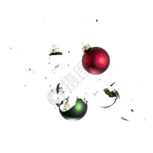 红色和绿色的圣诞球像爆炸圣诞晚会圣诞球一样冲击破碎的白色背景图片