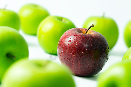红苹果站在绿色苹果中间在图片