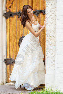 穿着白色婚纱的年轻美人新娘站在图片