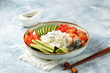 寿司碗有大米鲑鱼鳄梨黄瓜辣椒姜和芝图片