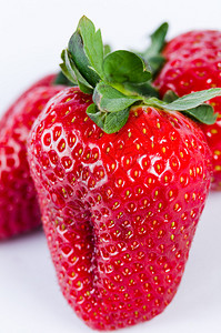 新鲜的红色开胃草莓白色背景上的绿叶图片