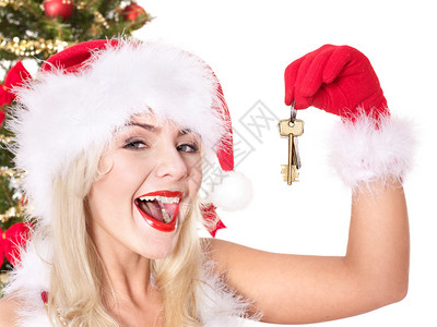 圣诞女孩穿着圣塔帽拿着房子钥图片