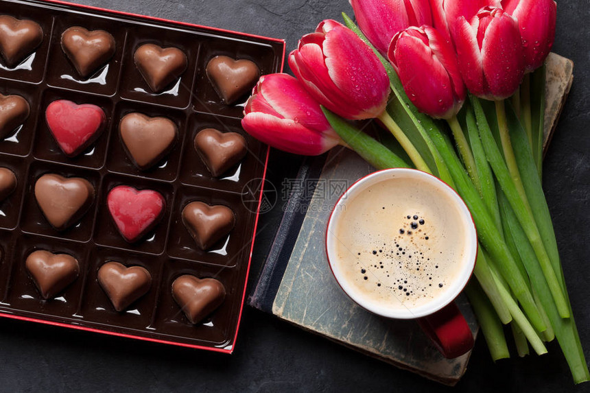 红郁金花束咖啡杯和巧克力心放在礼物盒中图片
