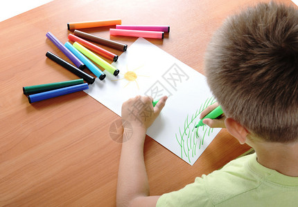 儿童用彩色笔在白纸上背景图片
