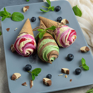 蓝莓草莓薄荷和巧克力冰淇淋在蓝色板图片