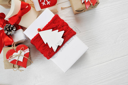 圣诞礼物盒装满了白木背景的红弓图片