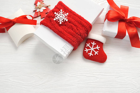 装饰品礼品盒和木板上的红弓的圣诞节背景图片