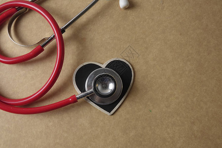 木制背景的红色听诊器医疗和保健概图片