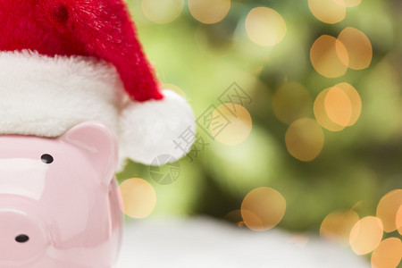 粉红色的存钱罐头戴红色和白色的圣诞帽图片