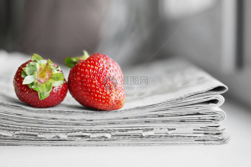 一堆报纸和草莓带有和文章以及新鲜水果的每日期刊多图片