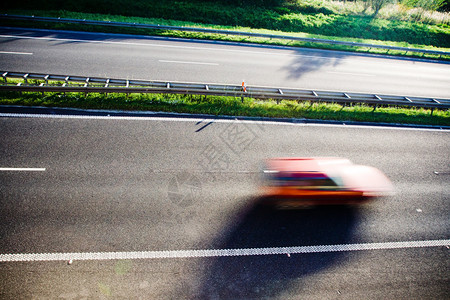 在高速公路上超速行驶的模糊红色汽车图片