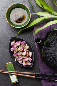 亚洲寿司筷子玫瑰茶和石桌上的茶壶图片