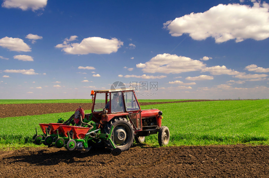 在阳光明媚的春天农民在农田图片