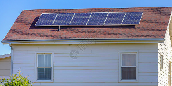 安装在房屋红色屋顶上的太阳能电池板图片