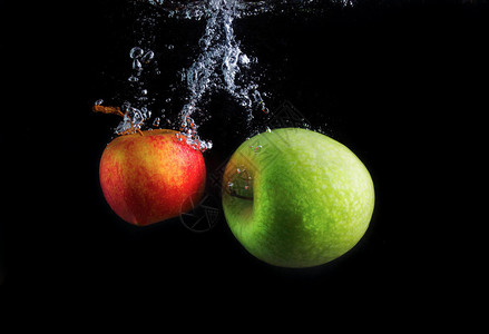 苹果落入水中溅起水花和气泡高速摄影图片