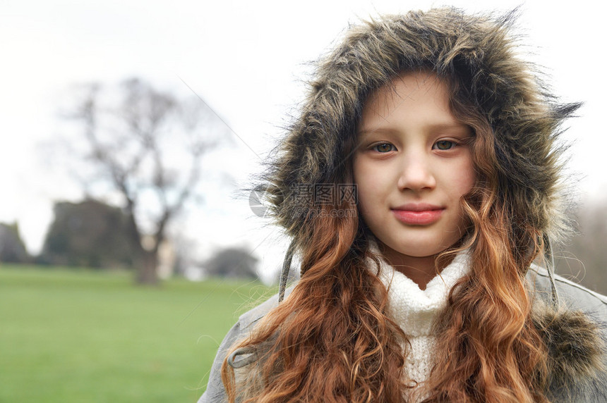一位迷人的年轻女孩在寒冬日穿着温暖大衣图片