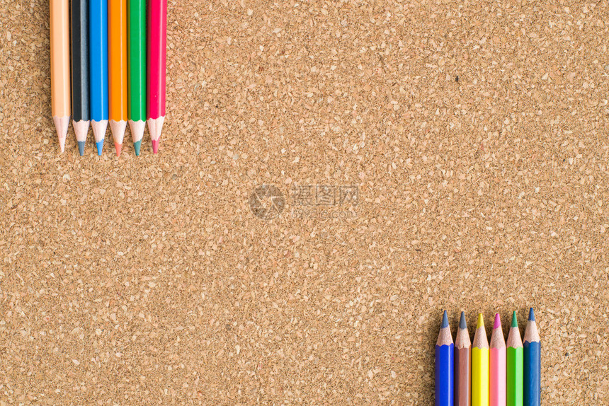 软木板背景上的彩色铅笔特写图片