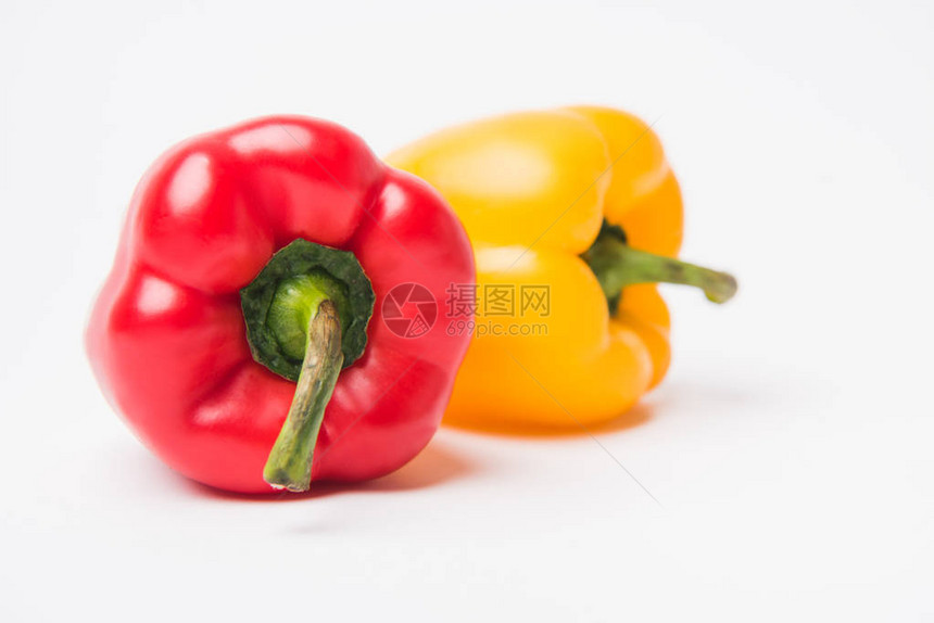 放置在白色背景的红色和黄色未加工的甜椒图片