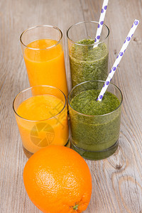 新鲜的橙子和菠菜冰沙饮料木质背景图片