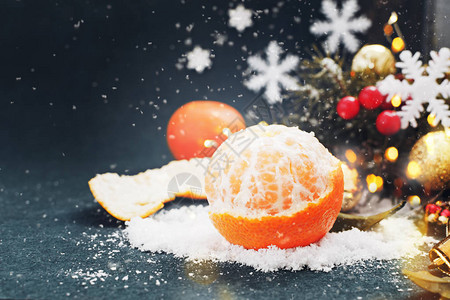 深蓝色背景上的圣诞装饰中带雪的橘子圣诞节或新年的概图片