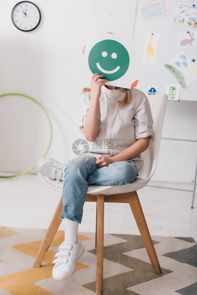 小孩坐在椅子上用微笑的图片