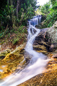 美丽的丝绸瀑布通过石块流经泰国清迈图片