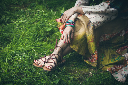 女人的腿被绑在平板凉鞋带上妇女穿着厚丽的丝绸裙图片