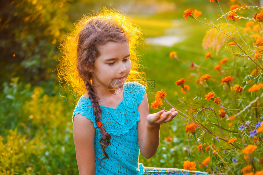 女童探索在大自然中探寻橙色花朵图片