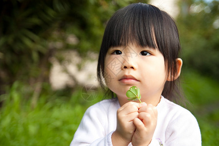 年幼的孩子手里拿着一株植物图片