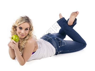 带着绿色苹果的笑脸女人在白色背景下抓着图片