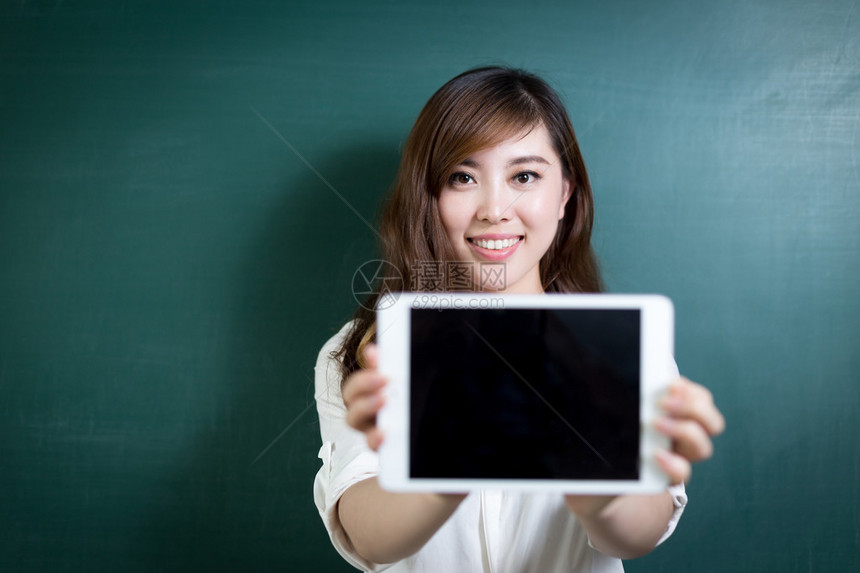 亚洲美女在黑板前拿着平板电脑图片