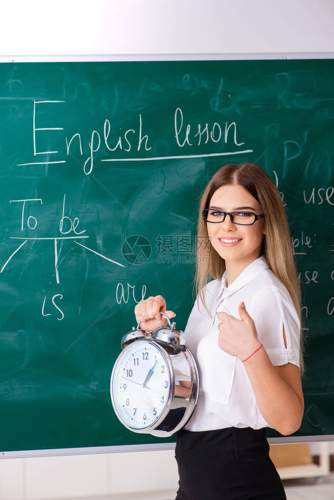 站在黑板前的年轻女英语教师图片