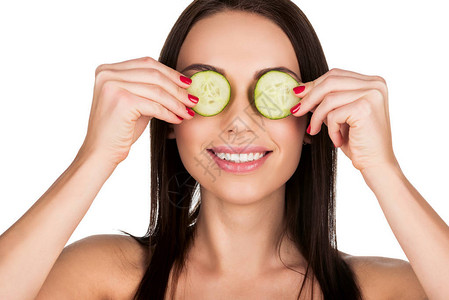 妇女用切黄瓜遮住眼睛图片