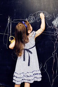 在黑板写笑容的教室里的可爱小女孩背景图片