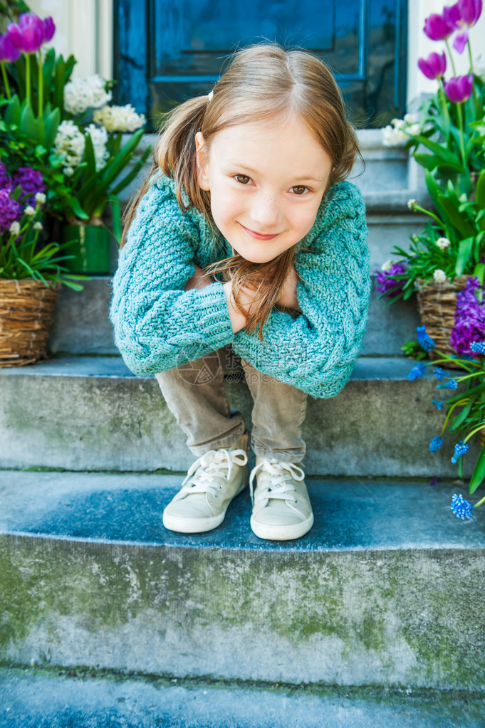 一个可爱小女孩的户外肖像坐在城市的台阶上图片