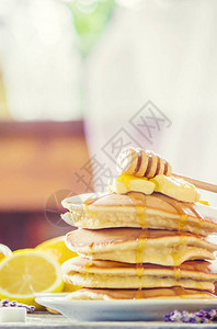 煎饼加黄油和蜂蜜还有早餐的柠檬茶有图片