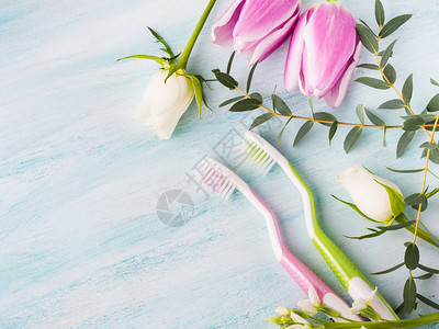 两把柔和的牙刷与花草本在绿色带纹理的背景春天的颜色个人牙科保健背景图片