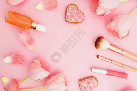 带有郁金香花和化妆品粉红糊面背景饼干的图利普框架背景图片