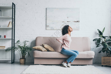 坐在沙发上睡在客厅的年轻非洲女士图片