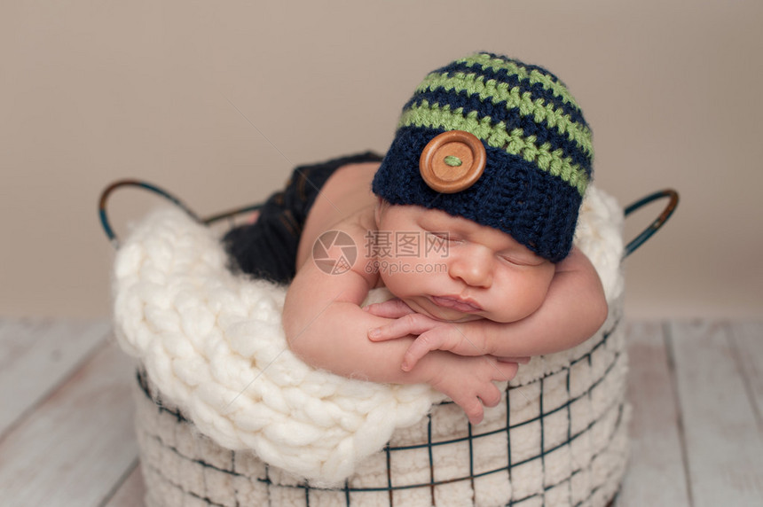 三个星期前刚出生的婴儿男孩穿着牛仔裤和一顶被编织的蓝色绿豆帽图片