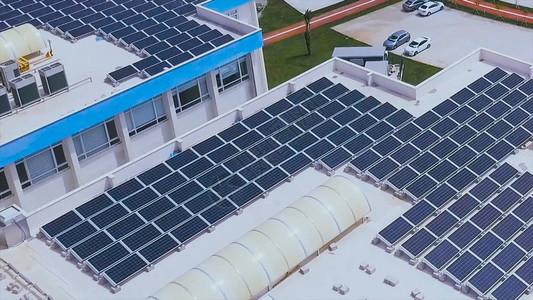 建筑屋顶上太阳能光伏板的鸟瞰图建筑屋顶上的太阳能蓝色面板在现代城背景图片