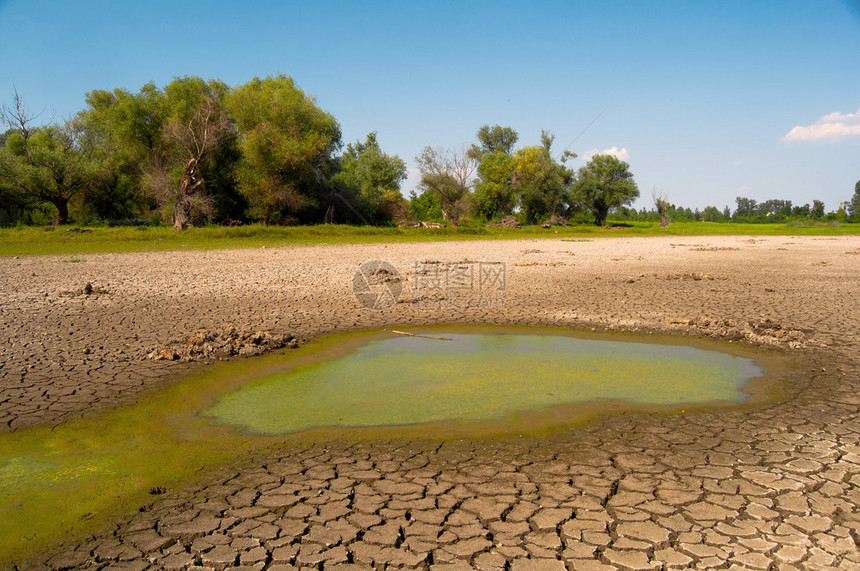 干旱期间干涸湖泊的污染水和裂土图片
