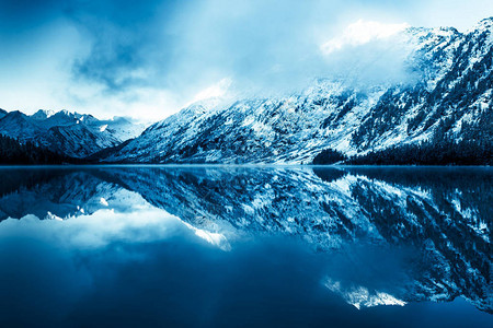 山中美丽的蓝色湖泊云层下水面的平面镜冬季自然之美穿越阿尔泰自然保护背景