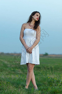 穿着白色衣服的年轻悲伤少女在夏图片