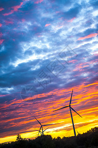 令人惊叹的日落时的风力涡轮机剪影图片